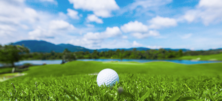 Golf ball on course, beautiful landscape with mountains on backgroundの写真素材