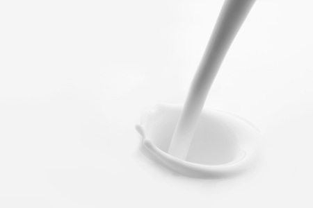 Pouring milk splash on white background macroの写真素材