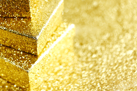 Stack of Gold decorative boxes with holiday gifts on abstract gold backgroundの写真素材