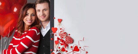 Happy couple posing with Valentine's day decoration with white copy space