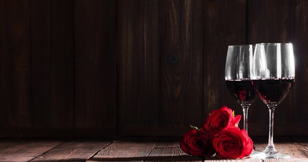 Two glasses of red wine and three roses, Valentine dayの写真素材