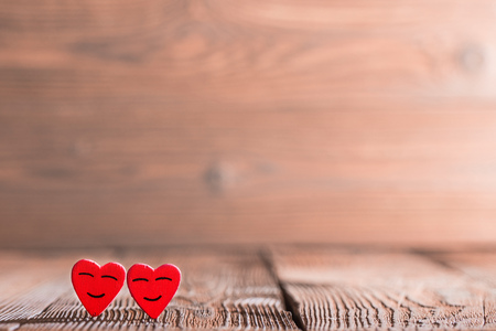 Two pink happy smiling hearts on wooden backgroundの写真素材