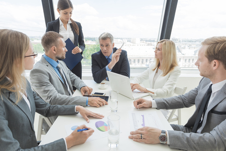 Mixed group of white collar workers at business meeting discuss documentsの写真素材