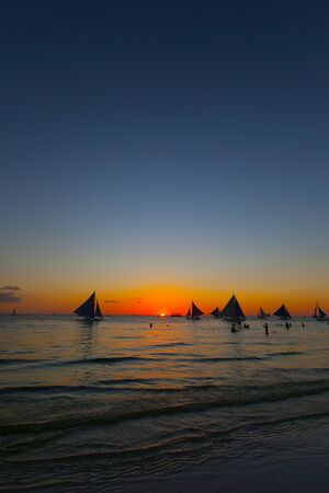 Beautiful sunset sky over the sea background and yachts at horizonの写真素材