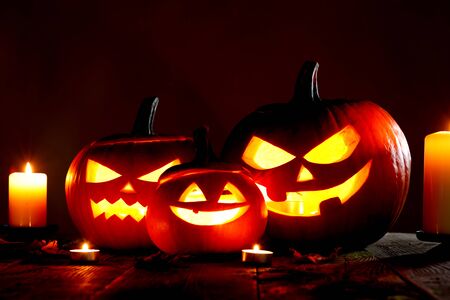 Halloween pumpkin head jack o lantern and candles on gray backgroundの写真素材