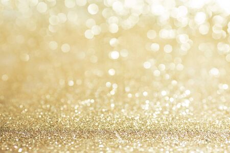 Shiny golden bokeh glitter lights abstract background, Christmas New Year party celebration conceptの写真素材
