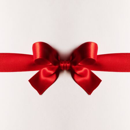 Red gift satin bow on white backgroundの写真素材
