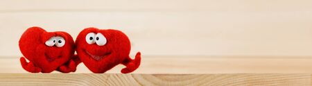 Two wool red hearts on wooden background with copy space for text, symbol of love, healtcare, valentines day conceptの写真素材