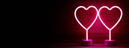 Two glowing pink neon hearts Valentines day party conceptの写真素材
