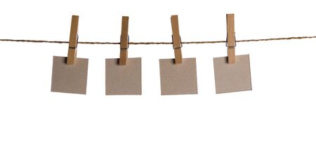 Set of four blank paper notes held on a string with clothespins isolated on white backgroundの写真素材