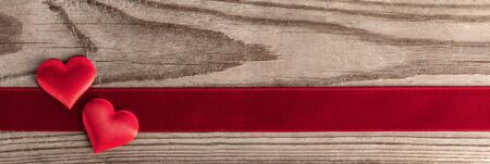 Valentine's day two red silk hearts and ribbon stripe on wooden background, love conceptの写真素材
