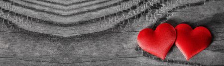 Valentine's day two red silk hearts on wooden background, love conceptの写真素材