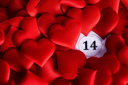 Valentine's day red silk hearts on calendar with 14 february date background, love, celebration...