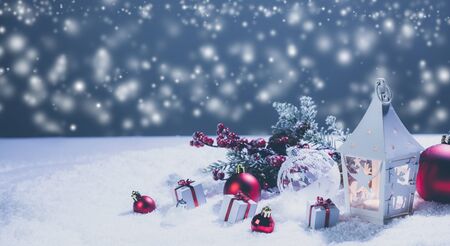 Lantern and red and white christmas decoration on snow and magic lights backgroundの写真素材