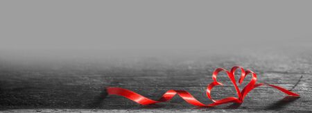 Two red ribbon hearts on wooden background with copy space for text, Valentines day conceptの写真素材