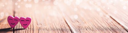 Two pink smiling hearts on wooden background with copy space for textの写真素材
