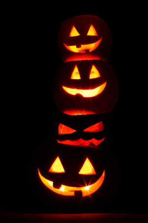 Pile of glowing Carved Halloween Pumpkins on black backgroundの写真素材