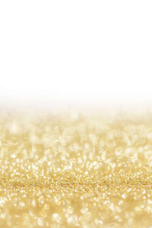 Shiny golden bokeh glitter lights abstract background, Christmas New Year party celebration conceptの写真素材