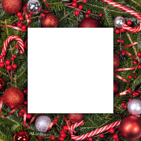 Blank white paper card framed with natural fir tree branches decor and bright red decor, wintry New...