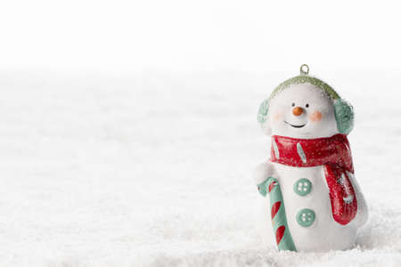 Christmas Snowman toy on winter background in the snowの写真素材