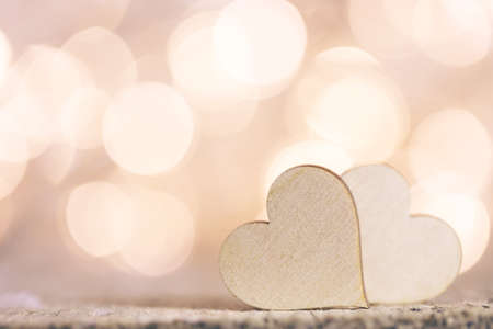 Two handmade wooden hearts on beautiful bokeh background. Vintage style. Love Valentine's Day concept.の写真素材