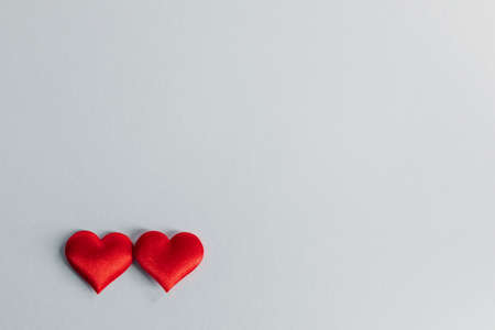 Valentine's day two red silk hearts on gray paper background, love conceptの写真素材