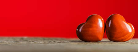 Valentine's day two red hearts on wooden background, love concept