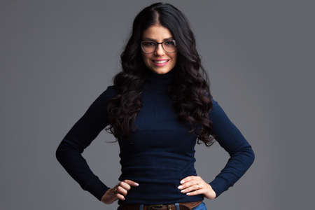 Portrait of beautiful brunette woman in glasses over gray backgroundの写真素材