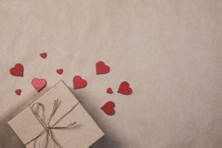 Box with gifts wrapped in brown craft paper and red paper hearts Valentines day conceptの写真素材