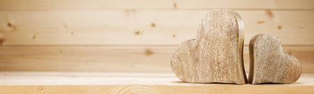 Two handmade carved hearts on wooden background with copy space for text couple relationship Valentine day conceptの写真素材