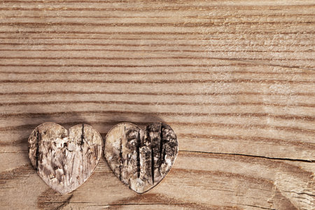 Two damaged rough rotten hearts on wooden background with copy space, love, Valentines day cardの写真素材