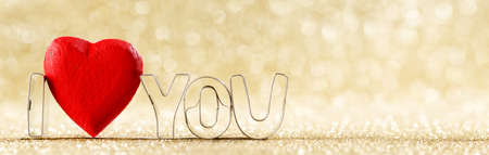 I love you and red handmade wooden heart on golden bright glitter lights bokeh backgroundの写真素材