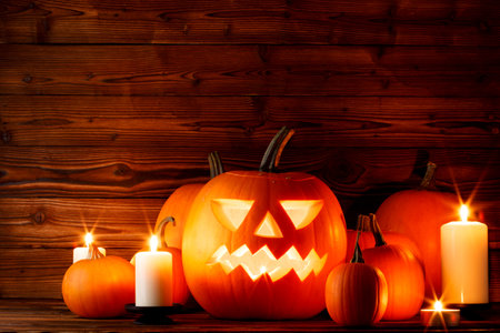 Halloween pumpkins with cut faces and candles dark holiday cardの写真素材