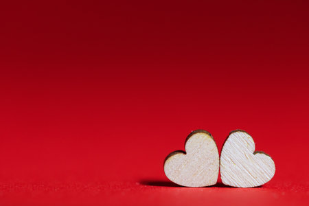 Valentines day red background with two wooden heartsの写真素材