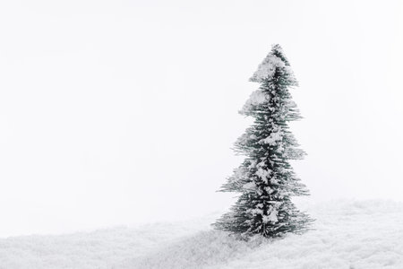 Miniature decorative Christmas tree placed on snow isolated on whiteの写真素材