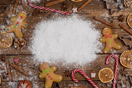 Christmas food frame. Gingerbread cookies, spices and decorations on wooden background with white copy space on snowの写真素材