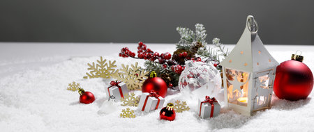 Christmas holidays card with gifts , balls , and white glowing lantern in snowの写真素材
