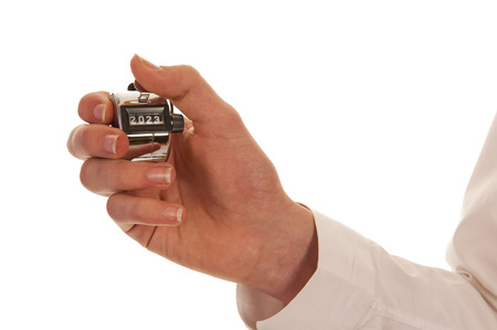 Hand holding a silver pedometer pressing its button isolated in white 