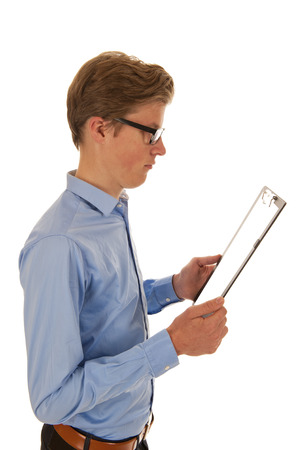Man in blue shirt holding and reading from a black clipboardの写真素材