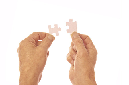 Two hands in silhouette connecting jigsaw puzzle pieces