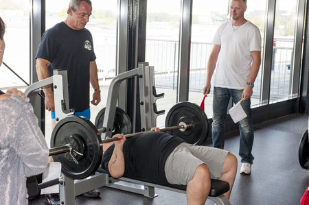 AMERSFOORT, THE NETHERLANDS - SEPTEMBER 13, 2014: Dutch grand prix strict curl at Amersfoort, the Netherlands on september 13, 2014. Female contestant performing the bench press earning the world title at sixty years of age.のeditorial素材