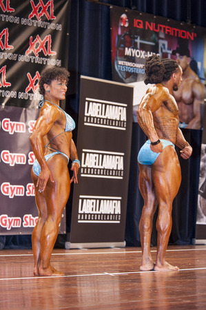 SCHIEDAM, THE NETHERLANDS - APRIL 26, 2015: Bodybuilding duo Floor van Putten and Grego Francisca show their relaxed side pose on stage at the 38th Dutch National Championship Bodybuilding and Fitness of the IFBB Netherlands (NBBF) on april 26, 2015 in Thのeditorial素材