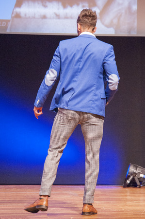 MAASTRICHT, THE NETHERLANDS - OCTOBER 25, 2015: Male fitness model dressed in suit shows his best on stage at the World Grandprix Bodybuilding and Fitness of the WBBF-WFF on October 25, 2015 at the MECC Theatre in Maastricht, the Netherlands.のeditorial素材