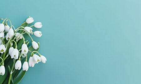 A snowdrop flowers bouquet on a pastel blue background with empty copyspace. mother's day concept. top view. Created with generative AI toolsの素材