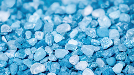 Close up of various sized blue pebbles creating a textured surface.の素材
