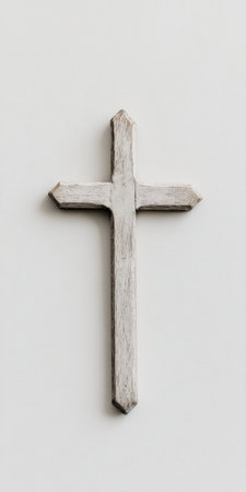 Rustic wooden Christian cross mounted on a white wall, symbolizing faith, spirituality, and religious devotion in minimalist decor.の素材