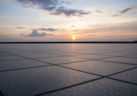 Wide tiled floor surface with calm sunset sky and clouds on the horizon creating a peaceful and tranquil outdoor atmosphere.の素材