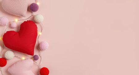 Soft fabric heart and round pillows with string lights on pastel pink background, cozy romantic holiday or valentine's day concept.の素材