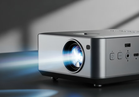 Modern home projector emitting bright light on table, sleek design with focus on lens, ports, and power buttons in daylight.の素材