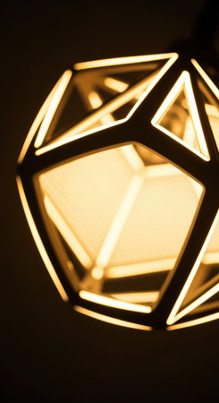 Modern geometric pendant lamp glowing warmly with intricate wireframe design, creating ambient lighting in a contemporary interior.の素材